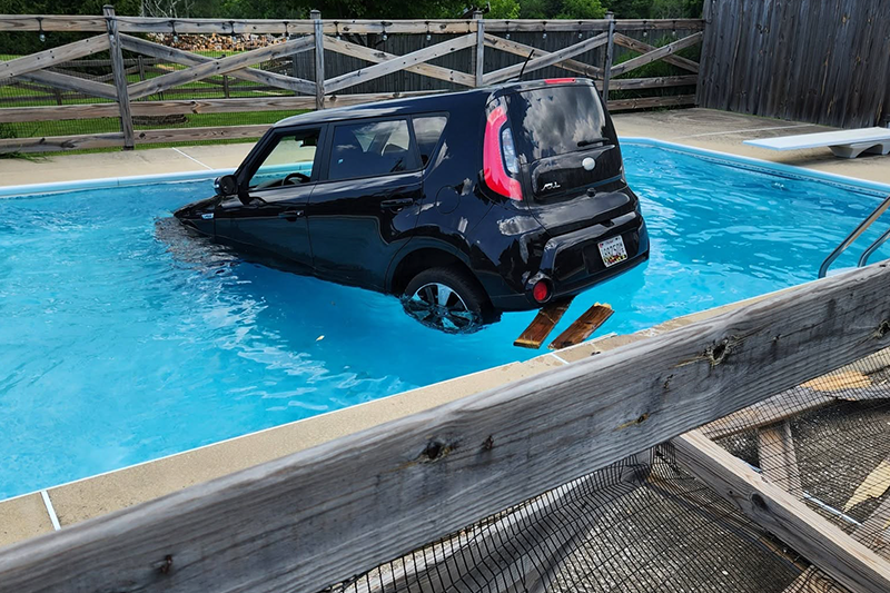 Black car sunk in a rectangle pool before vinyl pool liner replacement