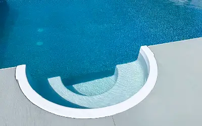 Cozy Cove Swimout curved bench in a blue vinyl pool