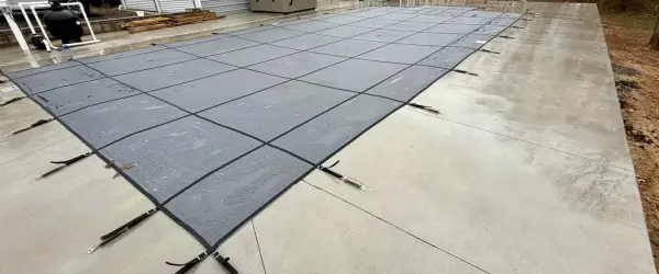 Mesh safety cover installed on a rectangular inground pool