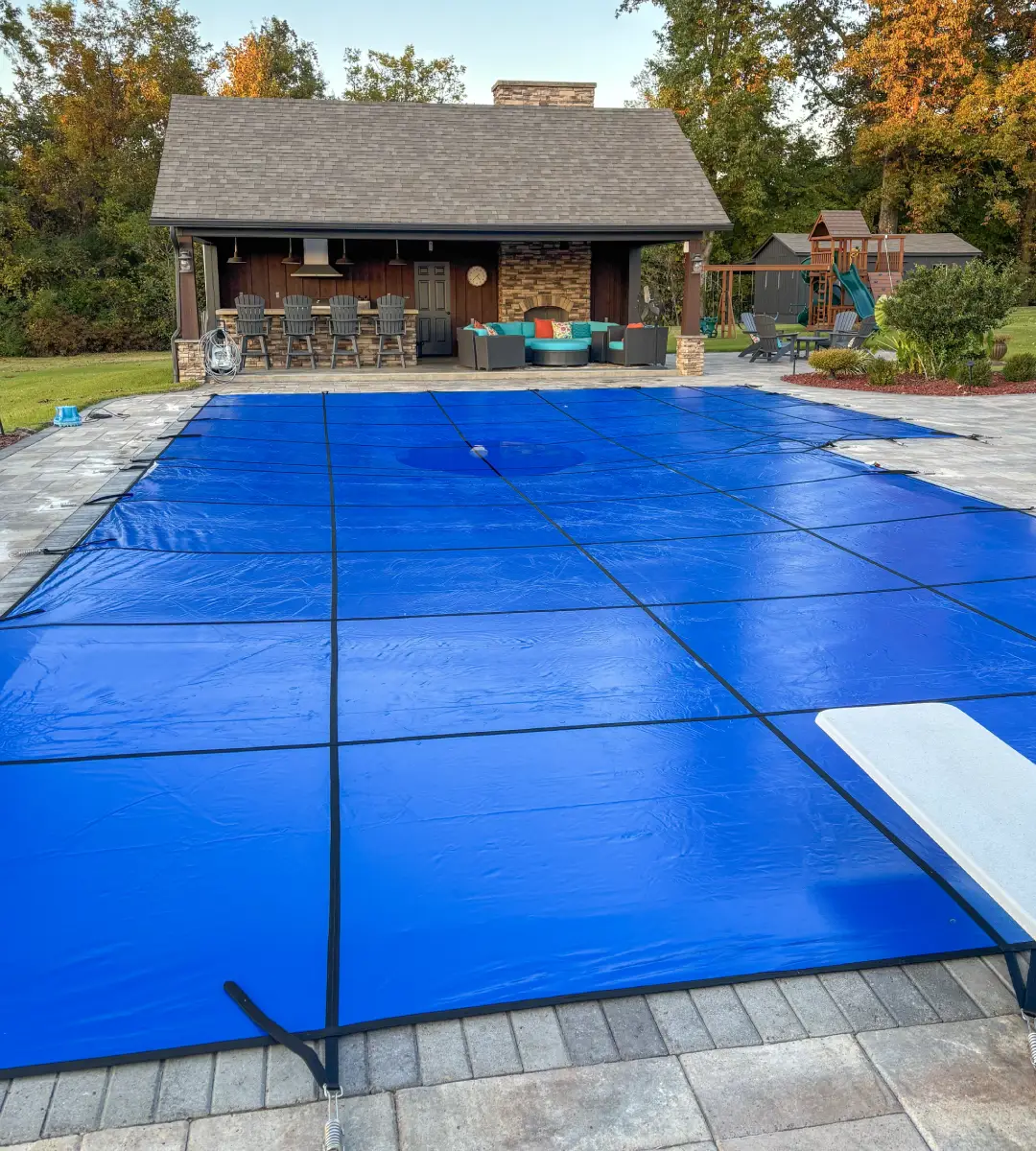 Blue solid vinyl safety cover on an 18 by 36 foot True-L pool