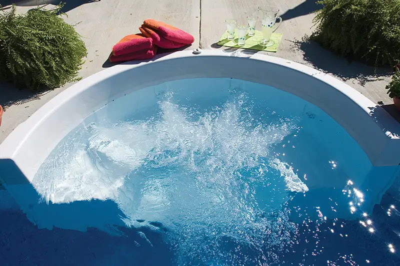 Close-up of a Cozy Cove Swimout bench in a vinyl pool