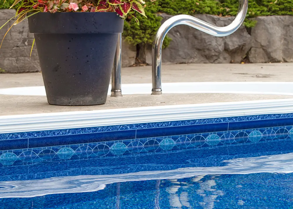Inground vinyl pool with a curved slide and custom liner