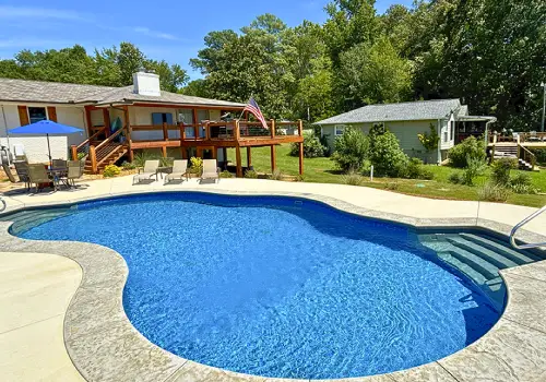 Freeform inground vinyl liner pool with a paved patio