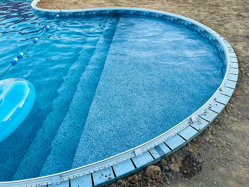 Inground pool with grey coping around the edge