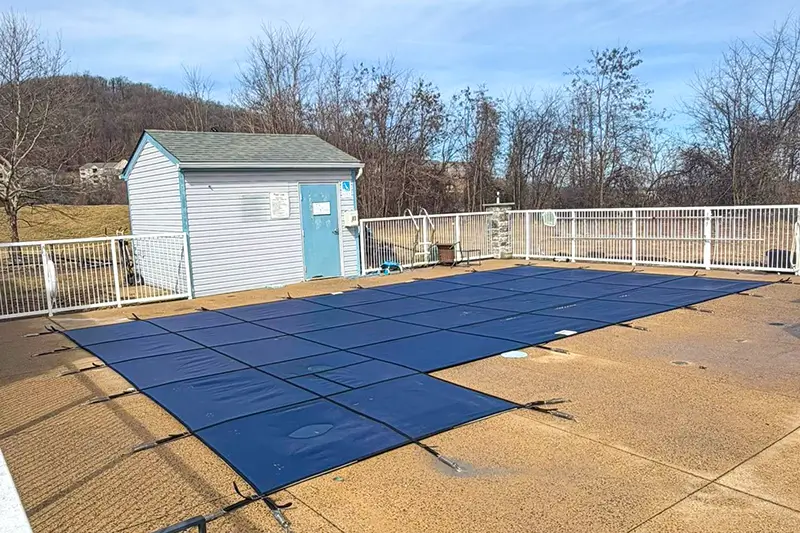 Solid vinyl safety cover installed on a closed inground pool