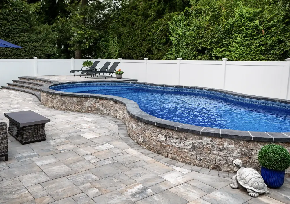 Semi-inground pool style with a vinyl liner on a sloped yard