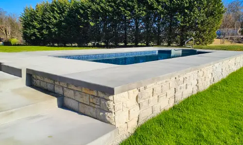 Semi-inground vinyl pool built into a sloped yard
