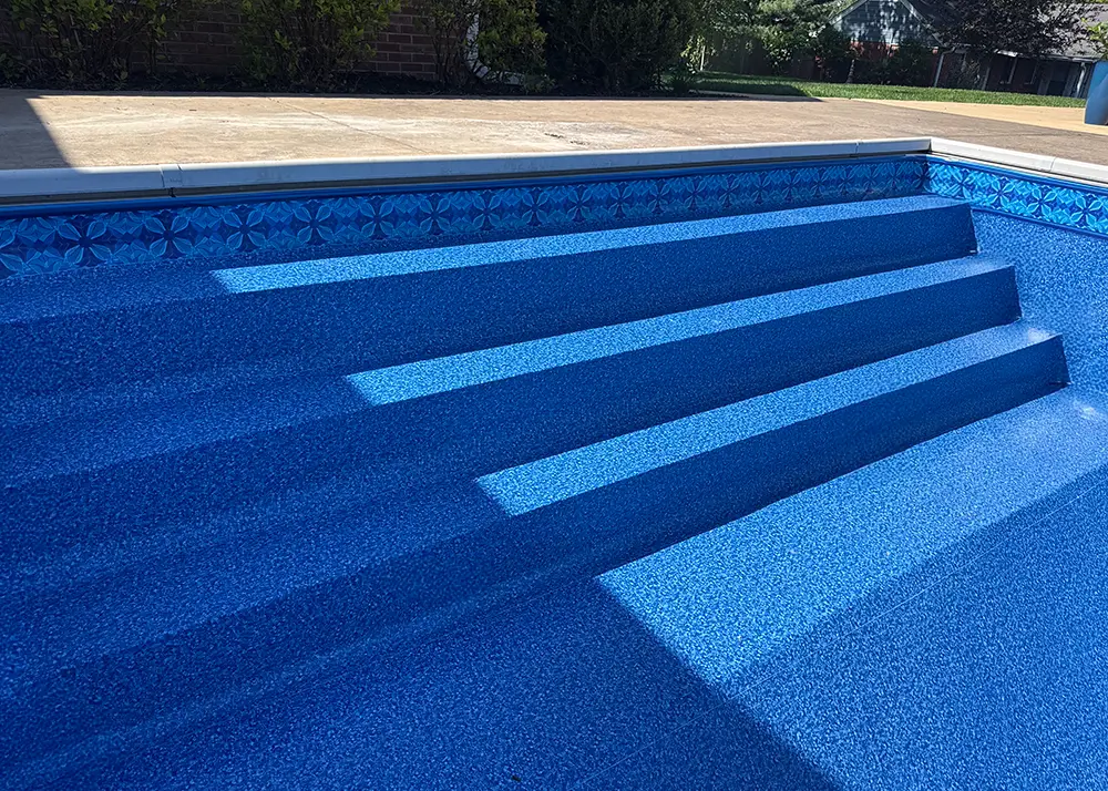Vinyl-covered steps and entry into an inground pool