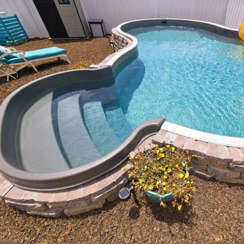 Semi-inground pool with a stone masonry surround