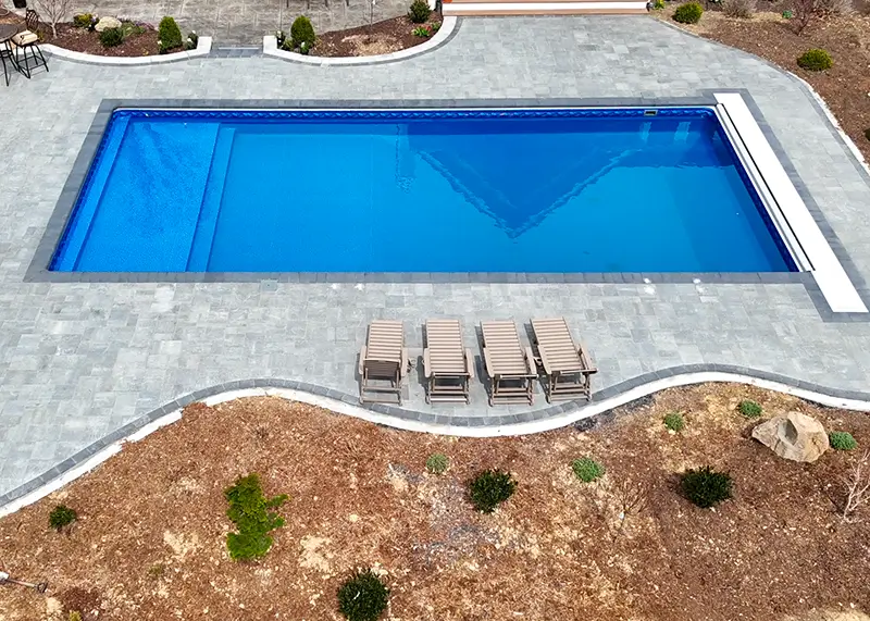 Freeform vinyl liner pool with a backyard patio