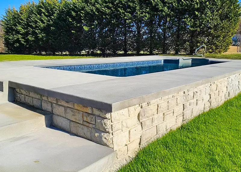 Inground vinyl pool with a raised spa, built by Hydra Pools