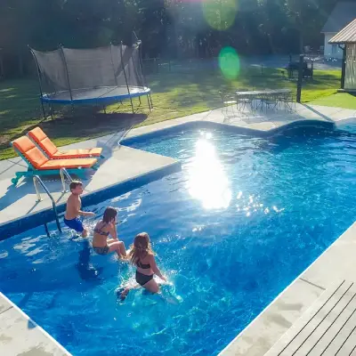 kids playing on sun ledge in vinyl liner pool with Seaglass all-over liner